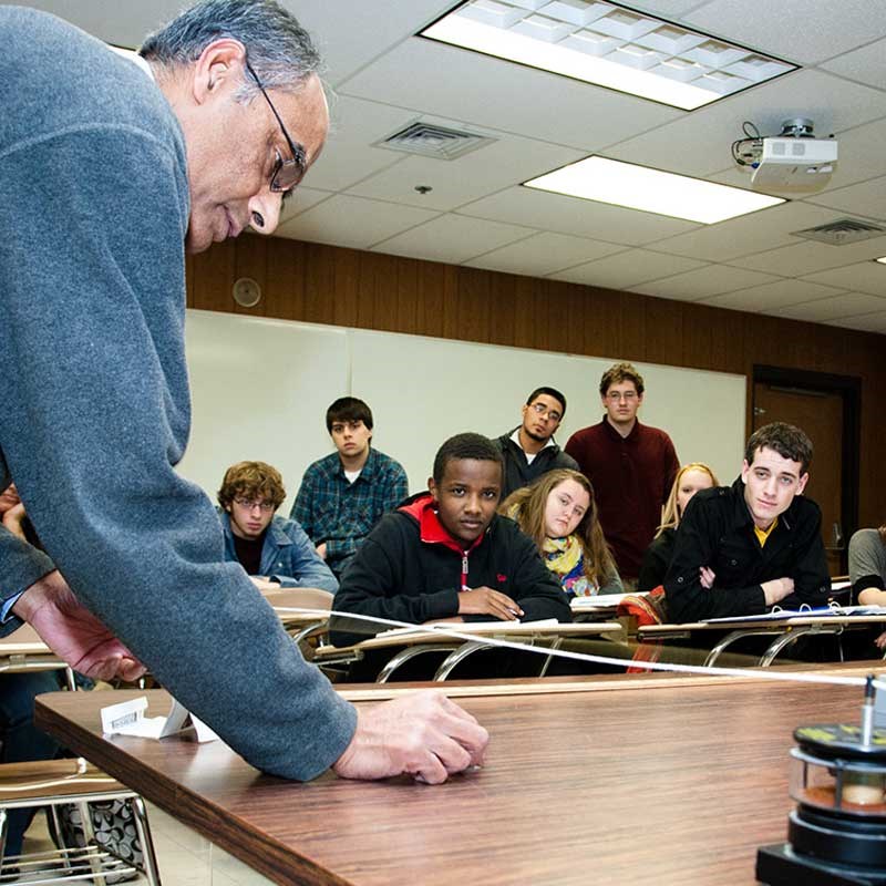 UMass Lowell physics professor demonstrates a string experiment while students observe.