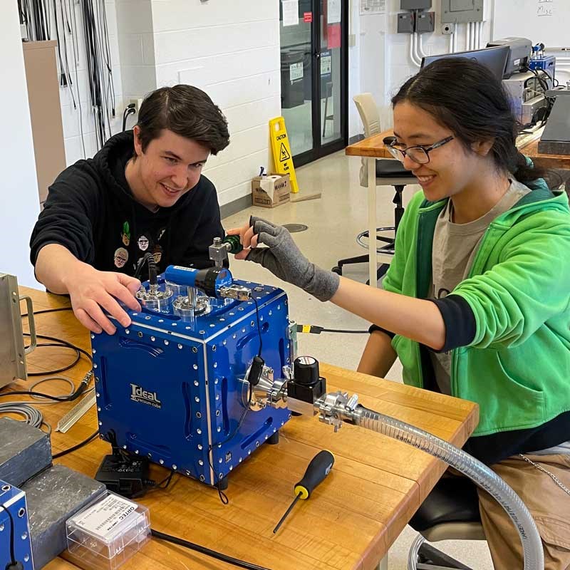 Physics students work with lab equipment at UMass Lowell
