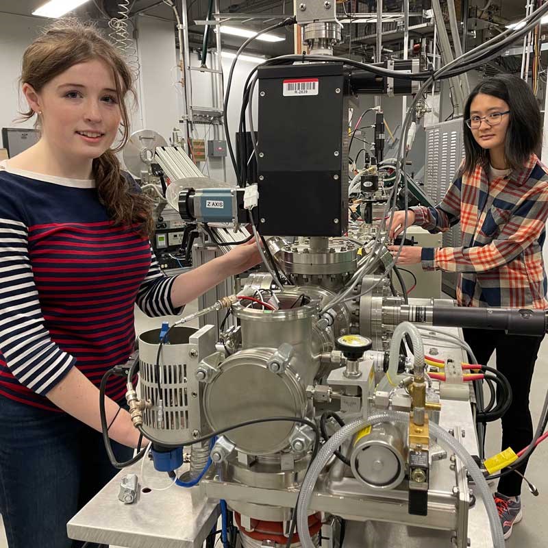 Two physics students work with equipment in a UMass Lowell lab