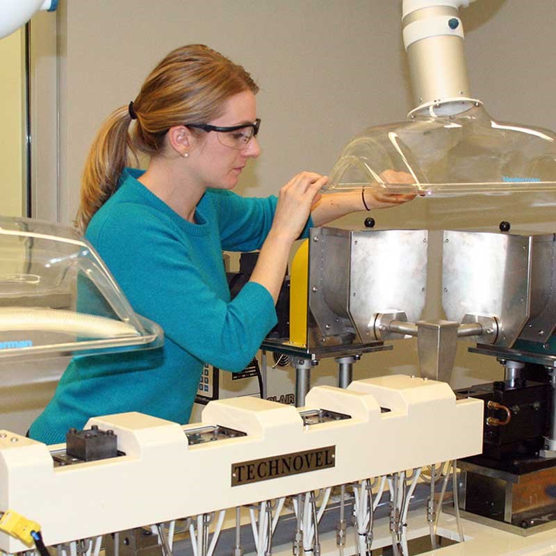 Plastics engineering professor works with equipment in a UMass Lowell lab
