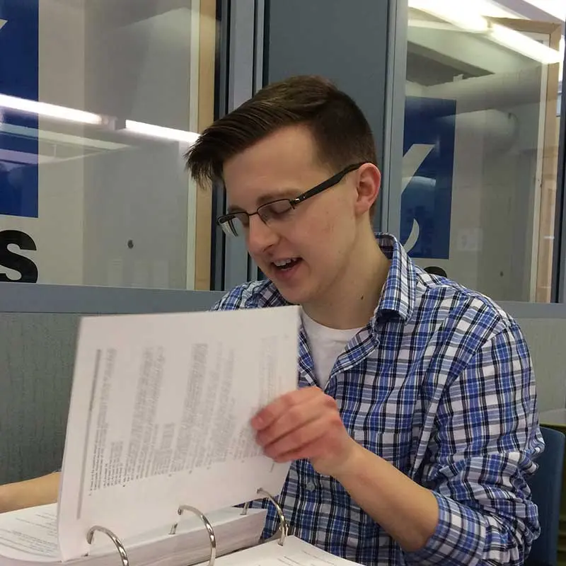 A UMass Lowell economics student reviews data in a notebook