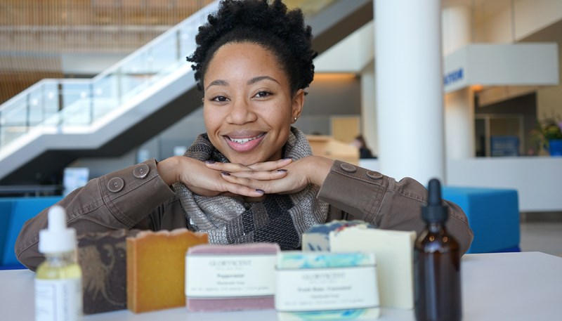 UMass Lowell student Rafaela Gonzalez poses with some of her GloryScent products