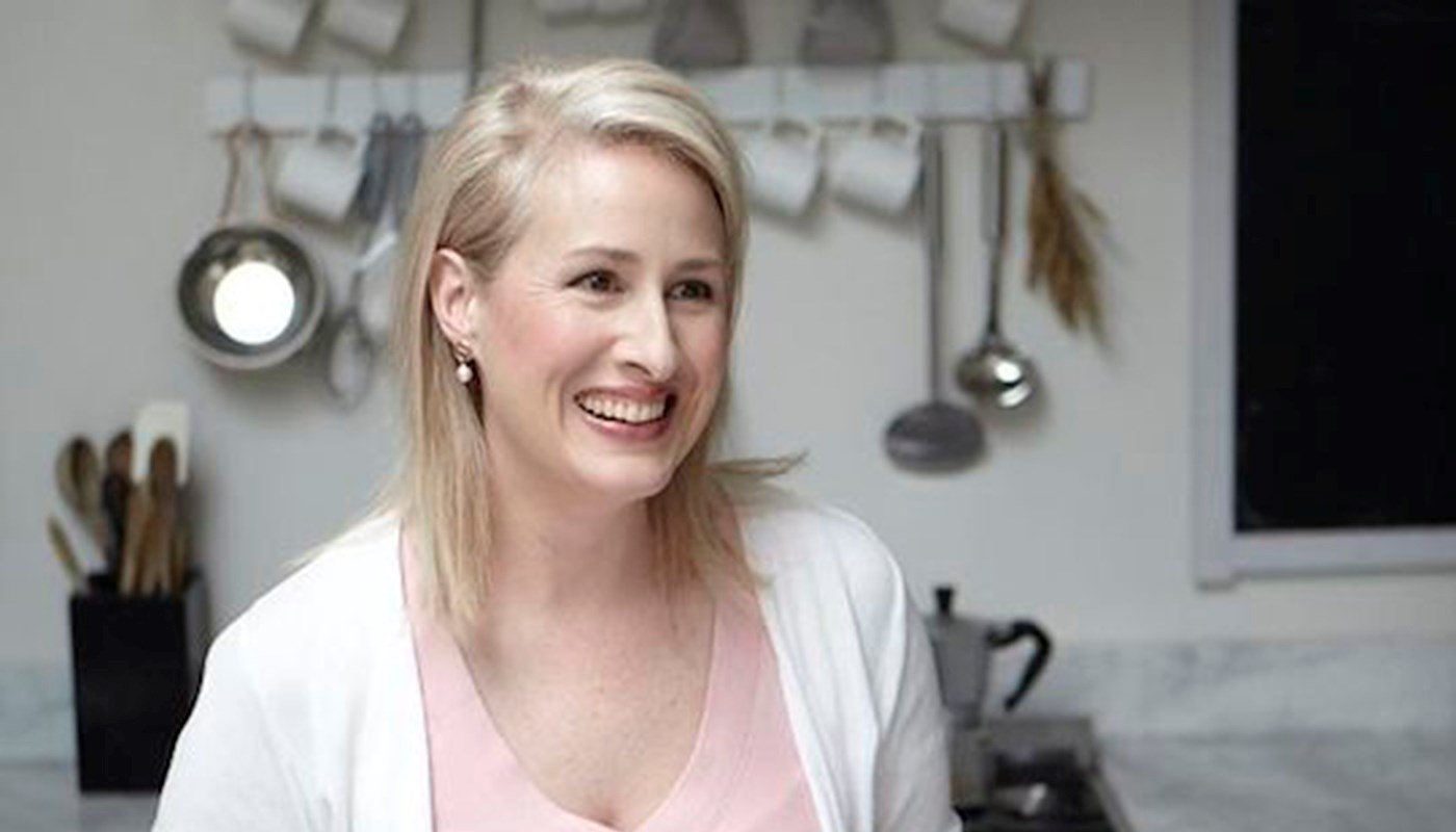 Renee Elliott, founder of Planet Organic, smiles in a clean white kitchen