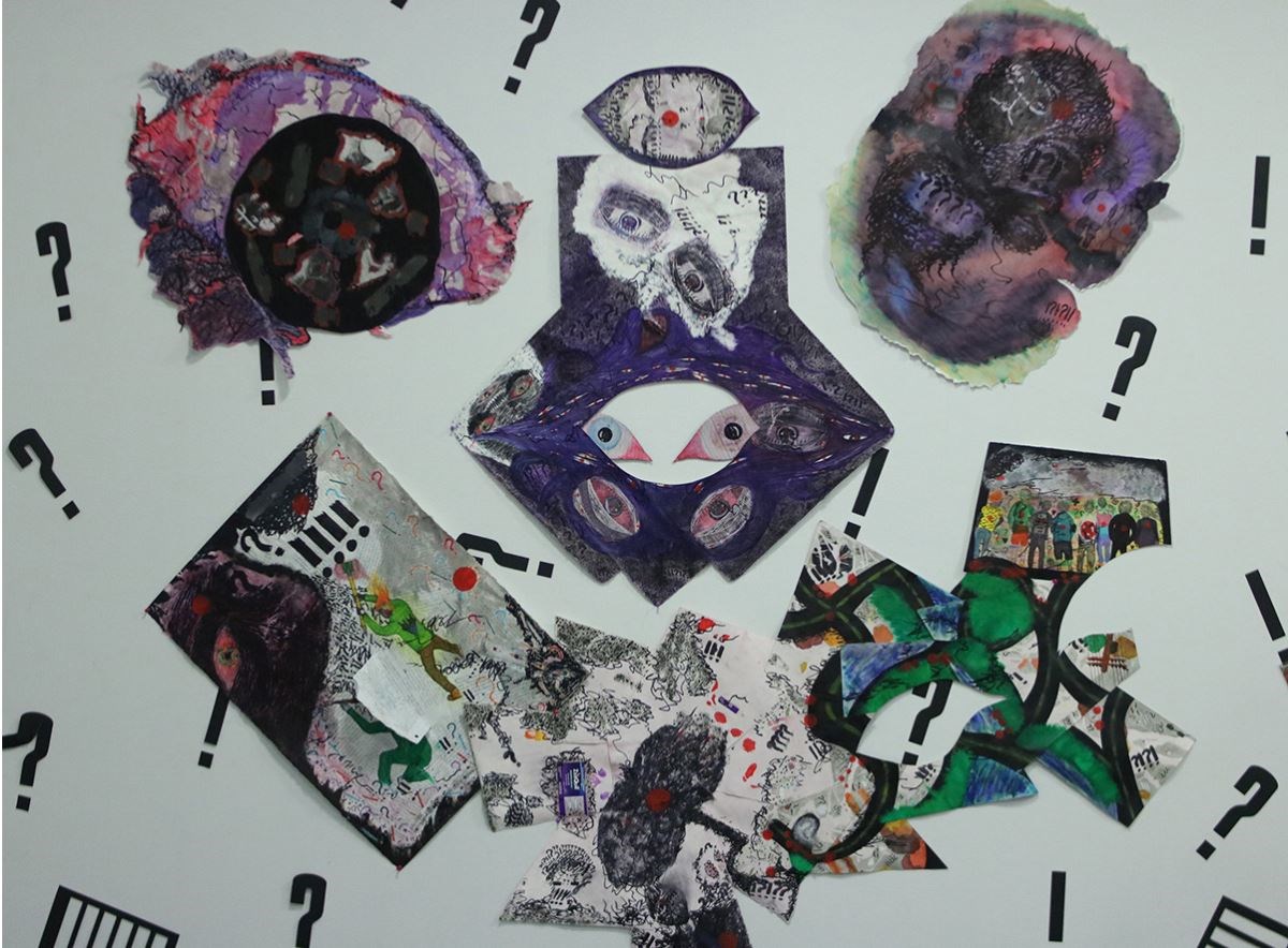 Student artwork with question marks and paintings