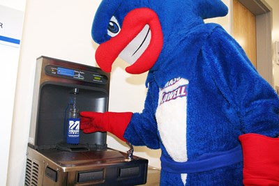 UMass Lowell mascot, Rowdy the River Hawk, fills up a reusable water bottle at one of the hydration stations located across the campuses. Having Hydration Stations easily accessible throughout campus reduces the usage of single-use water bottles.