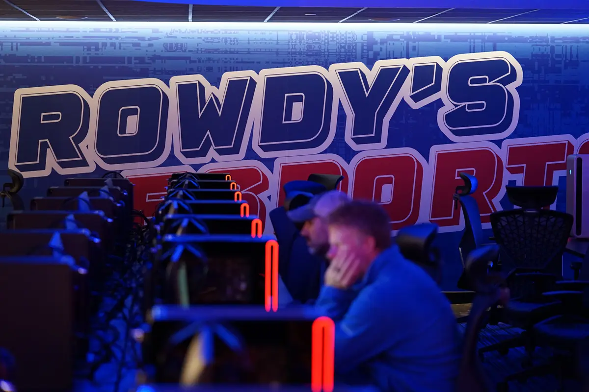 Students sit at gaming terminals with Rowdy's Esports on wall behind