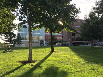 A picture of the Saab ETIC building in North Campus on a sunny day. It is surrounded by trees and very green grass can be also be seen.
