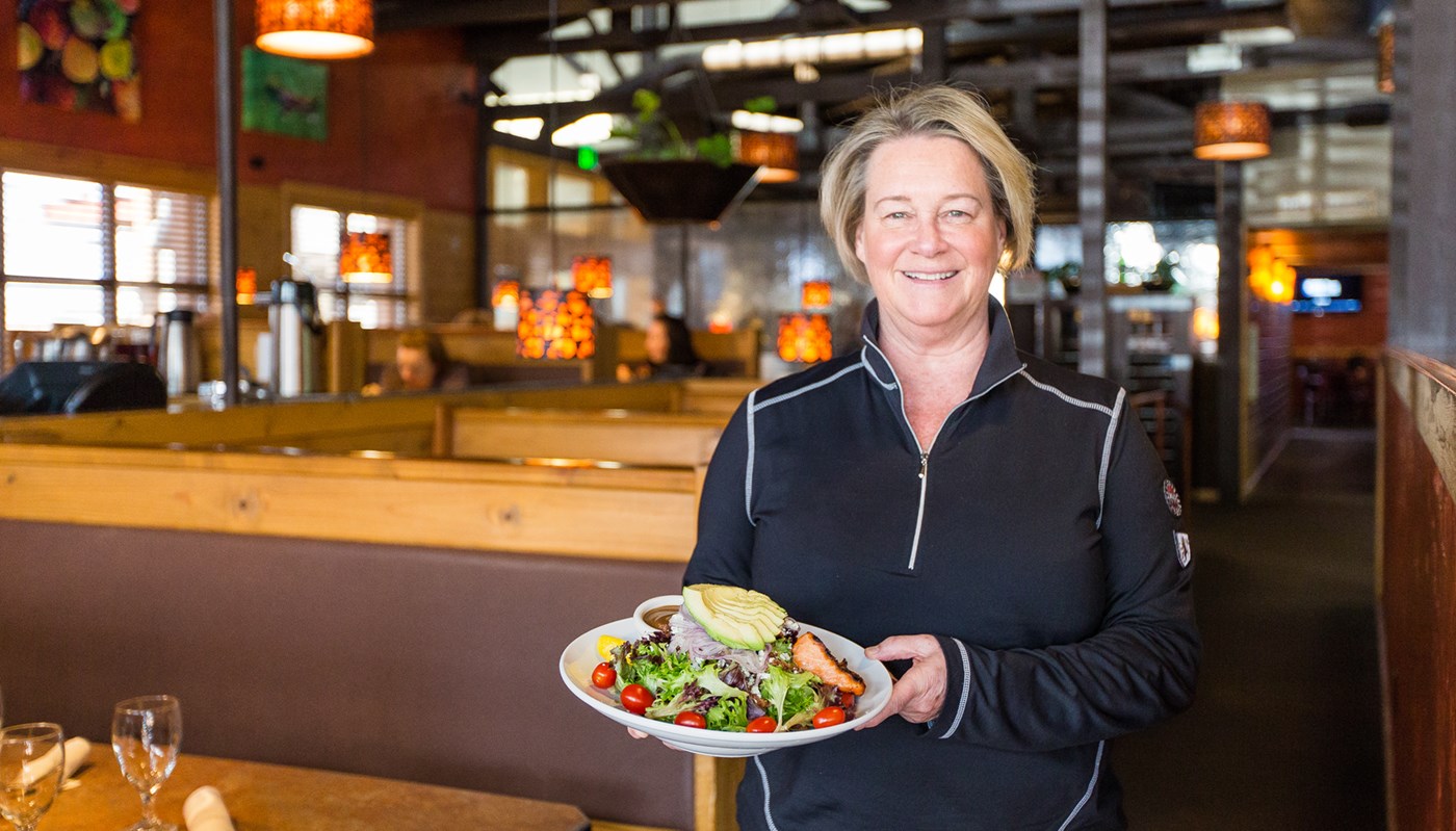 Sandy Green holds a salad at her restaurant The Phoenix in Bend, Ore.