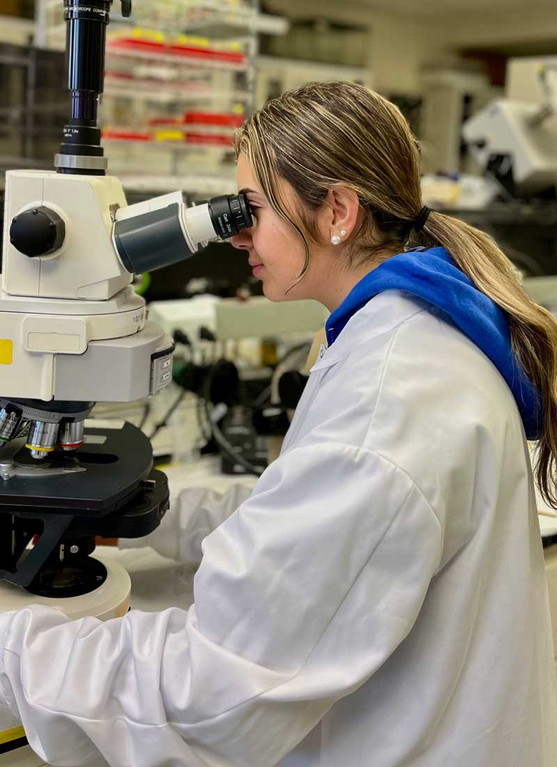 Sara Aldahabi looks through a microscope