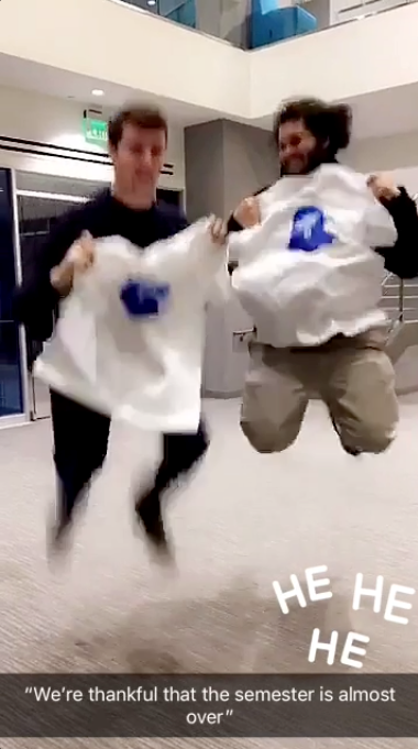 Two UMass Lowell students jumping with their Snapchat tees are "thankful that the semester is almost over"