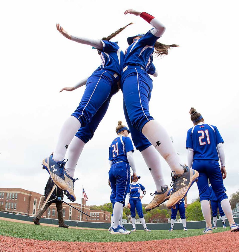 Two softball players celebrate on the field