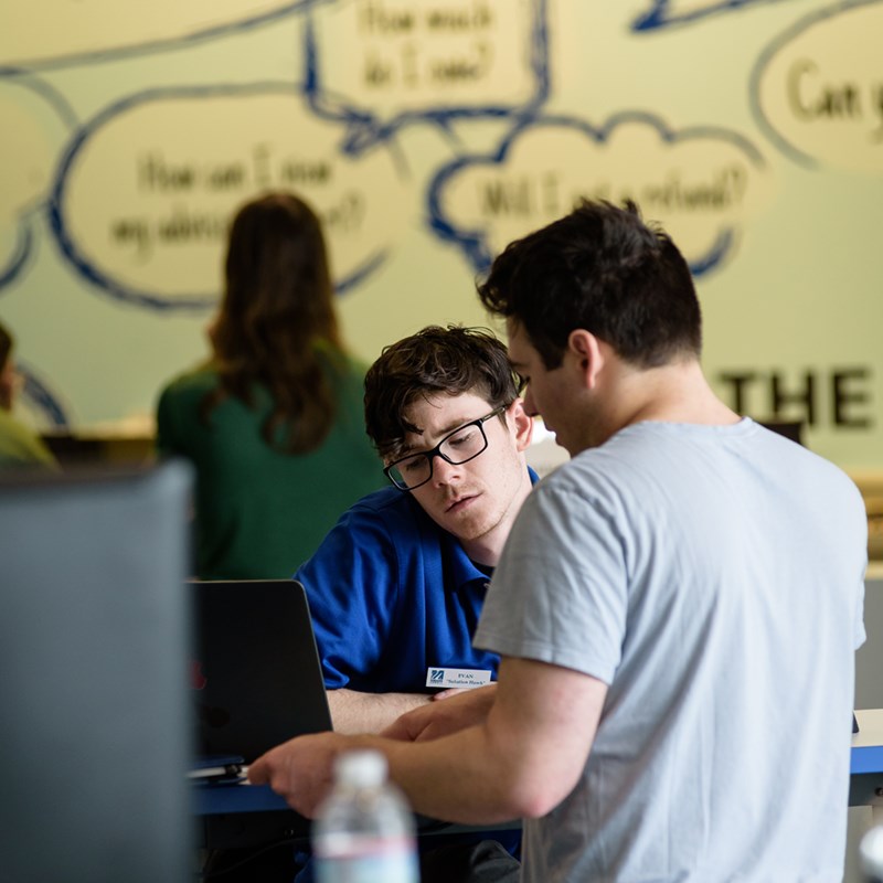 A student gets helped by a staff member at UML's Solution Center