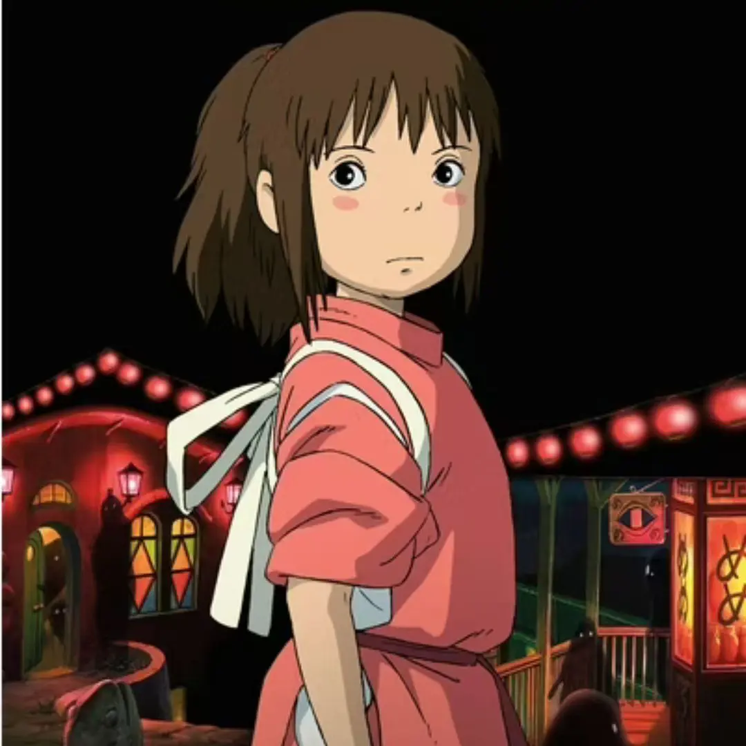 Spirited Away movie poster of a girl with brown hair and a pink outfit standing in front of a brightly lit building at night.