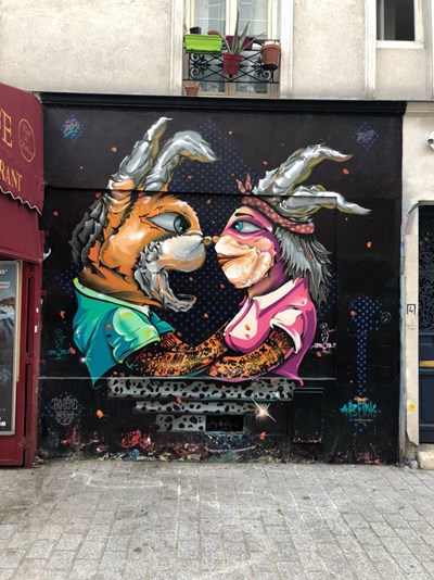 A painting of two rabbits as people - street art in Paris, France.