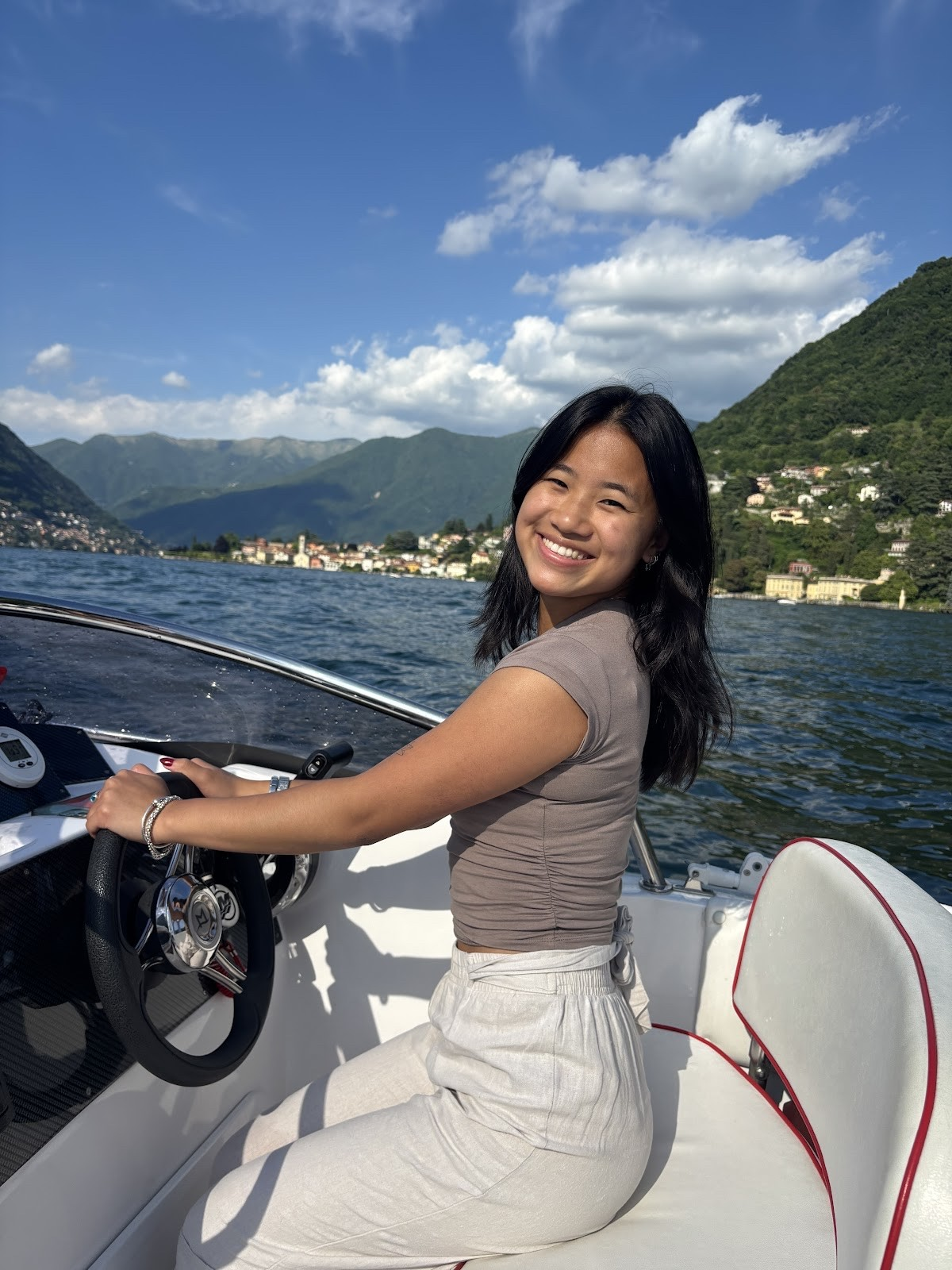 Student sitting behind the wheel on a boat while on a study abroad trip to Italy.