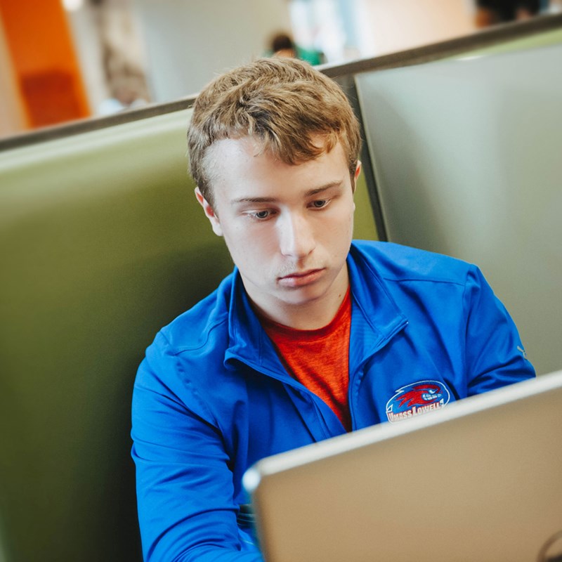 A male student works on a laptop.