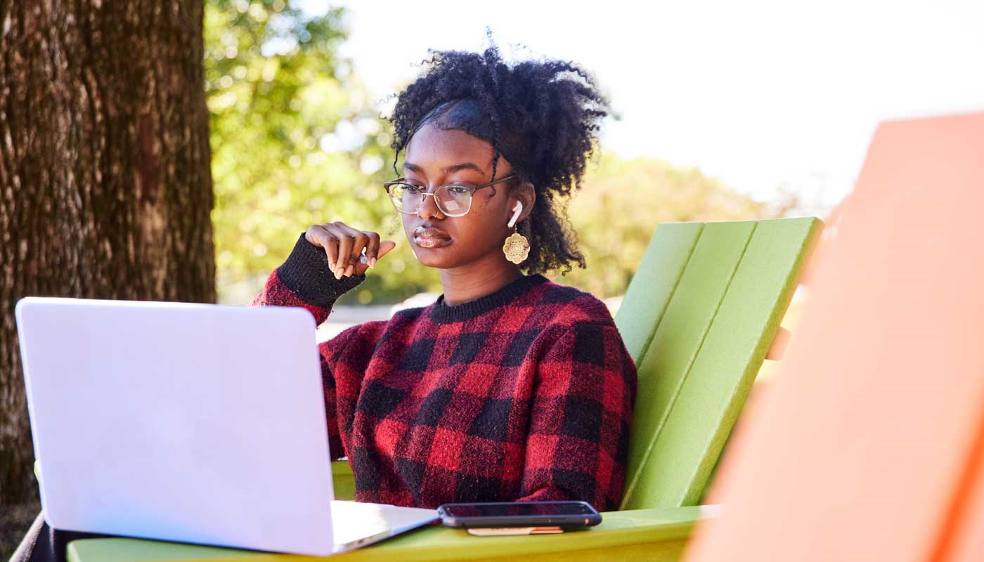 Student looking at laptop while outdoors