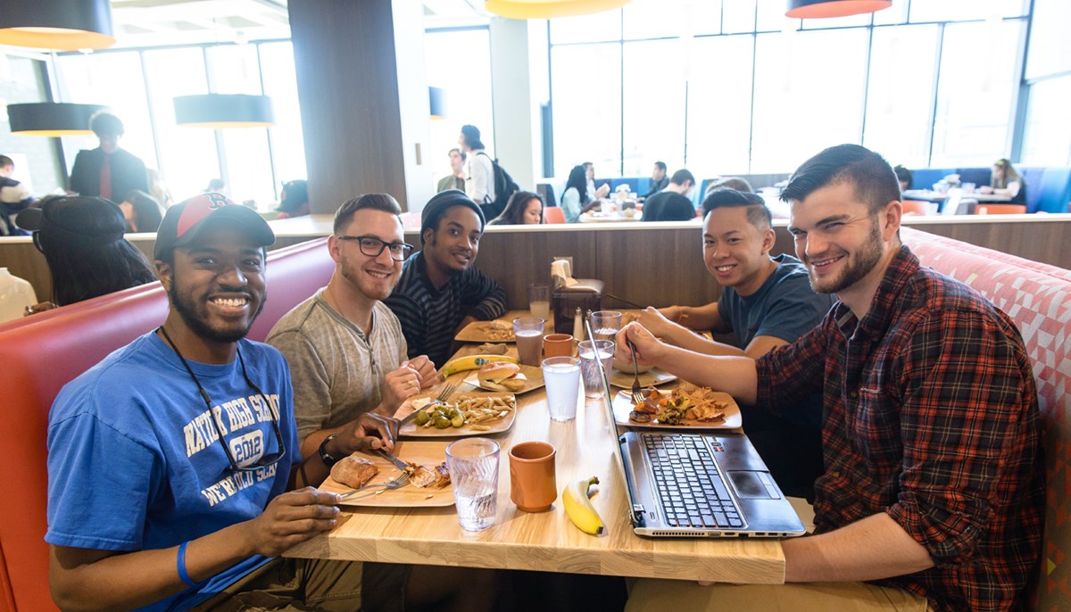 Students eat together at a table in UMass Lowell dining hall