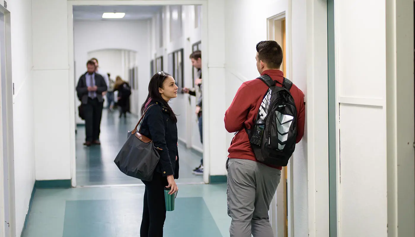 Students talk in class hallway at UMass Lowell