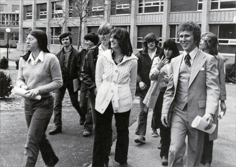 A group of students walk through UML's North campus in 1979, Olsen Hall in the background
