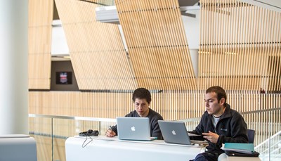 Two men with laptops studying in University Crossing