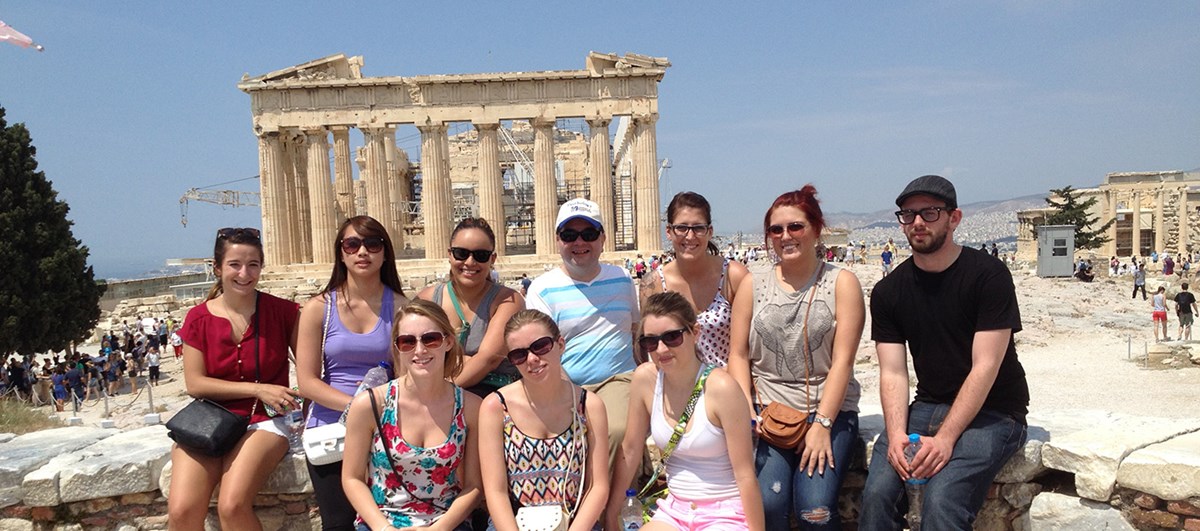 A group UMass Lowell Study Abroad students pose for a photo in front of ruins in Greece.