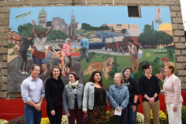 People stand in front of new mural