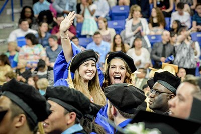 UMass Lowell graduates wave to family and friends in the crowd. 