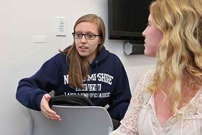 UMass Lowell junior Danielle Thibodeau, left, and sophomore Nicolette San Clemente talk about their work 