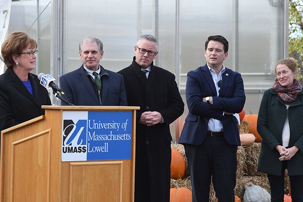 UMass Lowell Chancellor Jacquie Moloney, left, speaks at the UMass Lowell greenhouse while other look on.