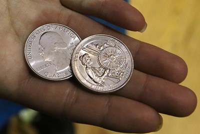 Closeup of new Lowell quarters in person's hand