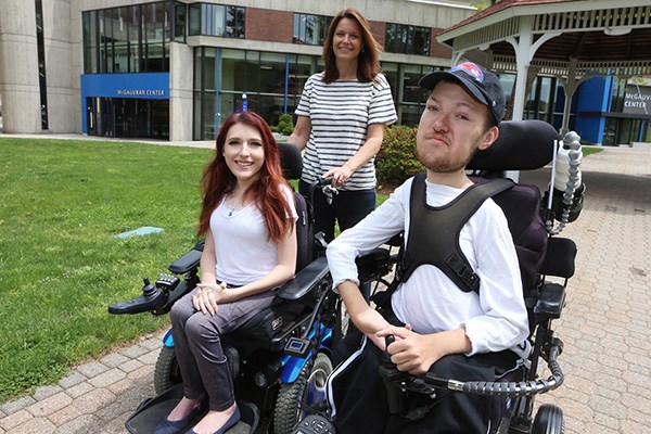 UMass Lowell senior Nicholas Raymond, 22, his sister Elizabeth, both in wheelchairs, and their mother, Kathy, outside on South Campus.