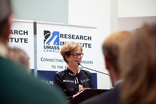 UMass Lowell Chancellor Jacquie Moloney at podium at Research Institute in Lincoln.