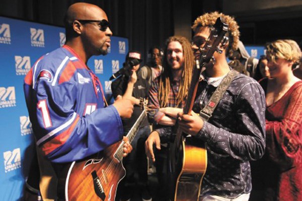 Pop star Wyclef Jean talks with Lowell High junior Brian Terrero.