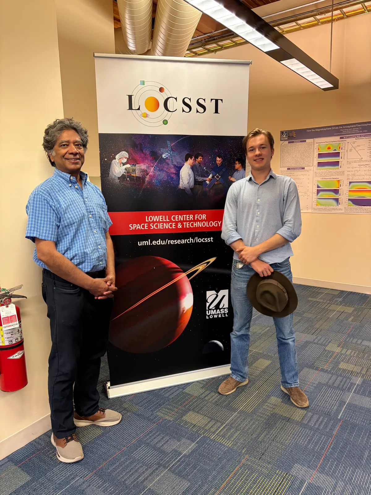 Professor Supriya Chakrabarti and Ihor Protsenko in front of their LoCSST sign at UMass Lowell.