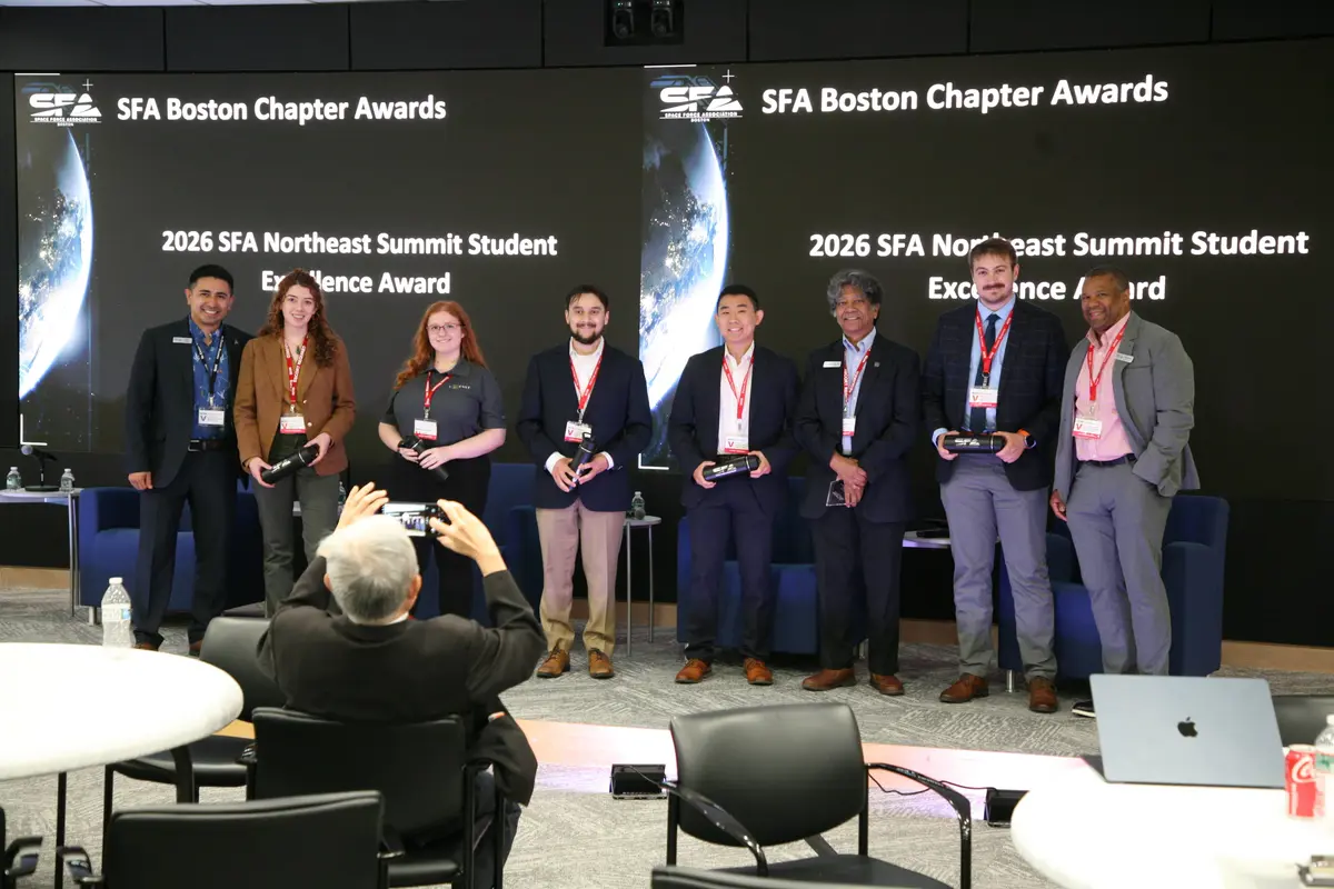 7 people standing with Professor Supriya Chakrabarti for his award at the SFA Boston Chapter Awards.