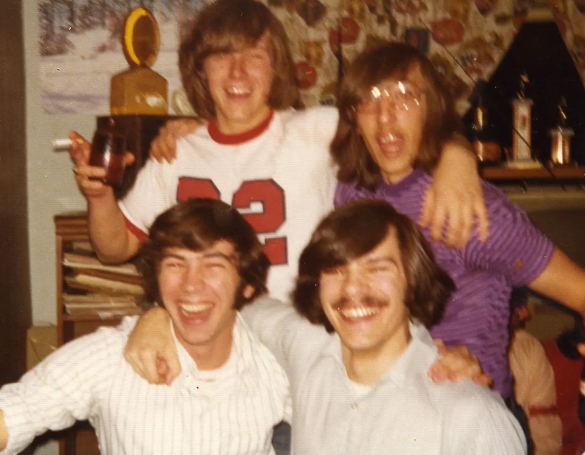 Four young men laugh in old photo