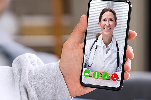 Hand holding cell phone with female doctor on it