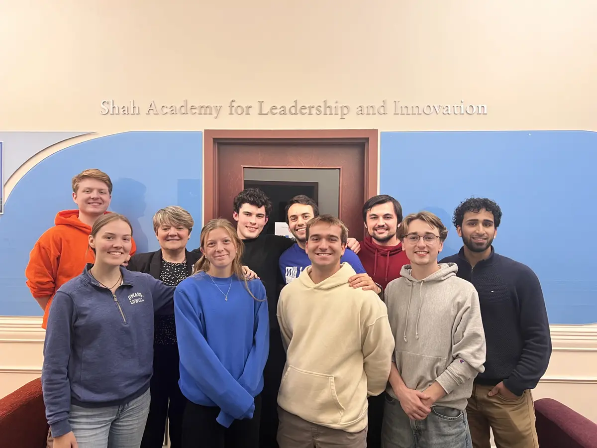 Shah academy scholars posing with a guest speaker in front of Shah Academy.
