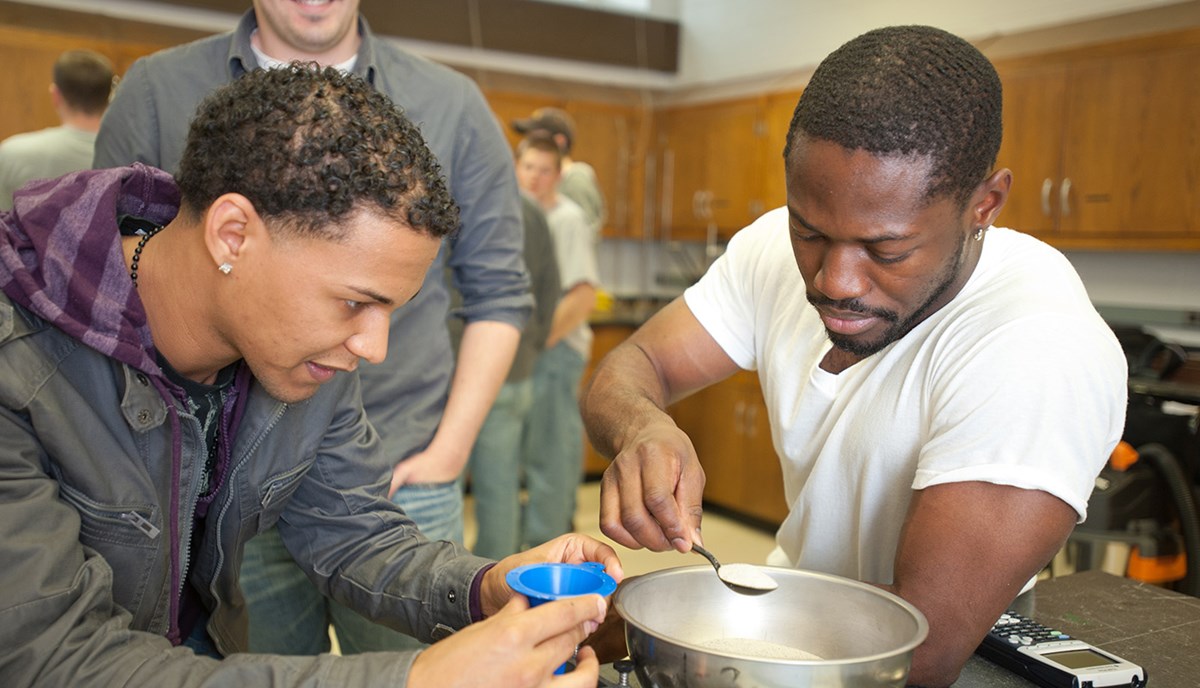 Two African American male UMass Lowell students working in a Civil & Environmental Engineering lab or class.