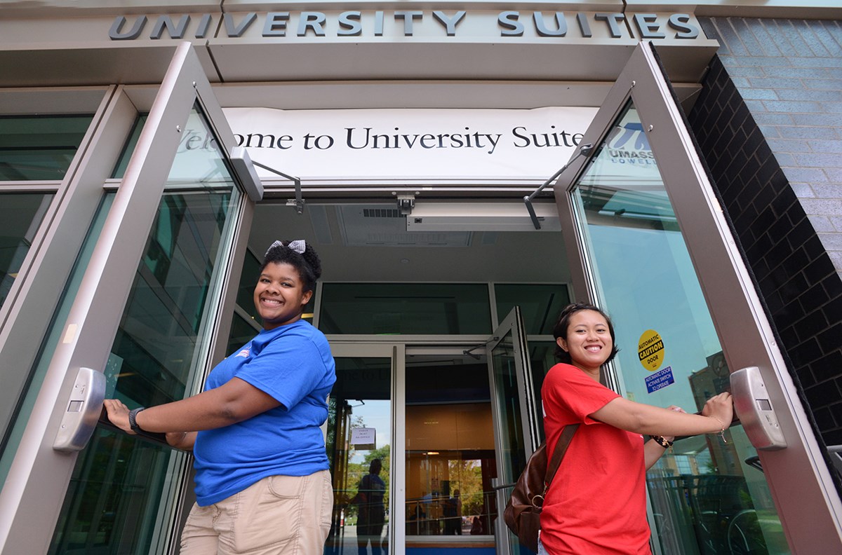 Two Residence Life staffers hold the doors to University Suites open during move-in.