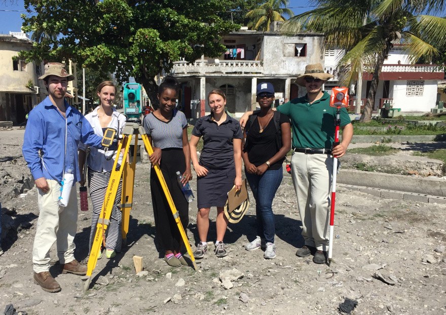 A UMass Lowell group of students and others pose with surveying equipment in Haiti.