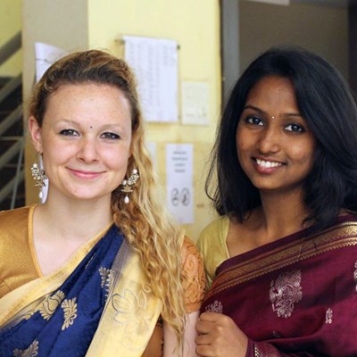 A UMass Lowell student poses with a young Indian woman - both in sarries from 2017-2018 UMass Lowell Winter Study Abroad trip to India. Blog post: The next morning we were woken up to be dressed by the hostel housekeeping women who wear sarries every day. It took them about 15 minutes or so to wrap and pin each of us to their liking. Then some of the Indian girl students did our make up and gave us jewelry.