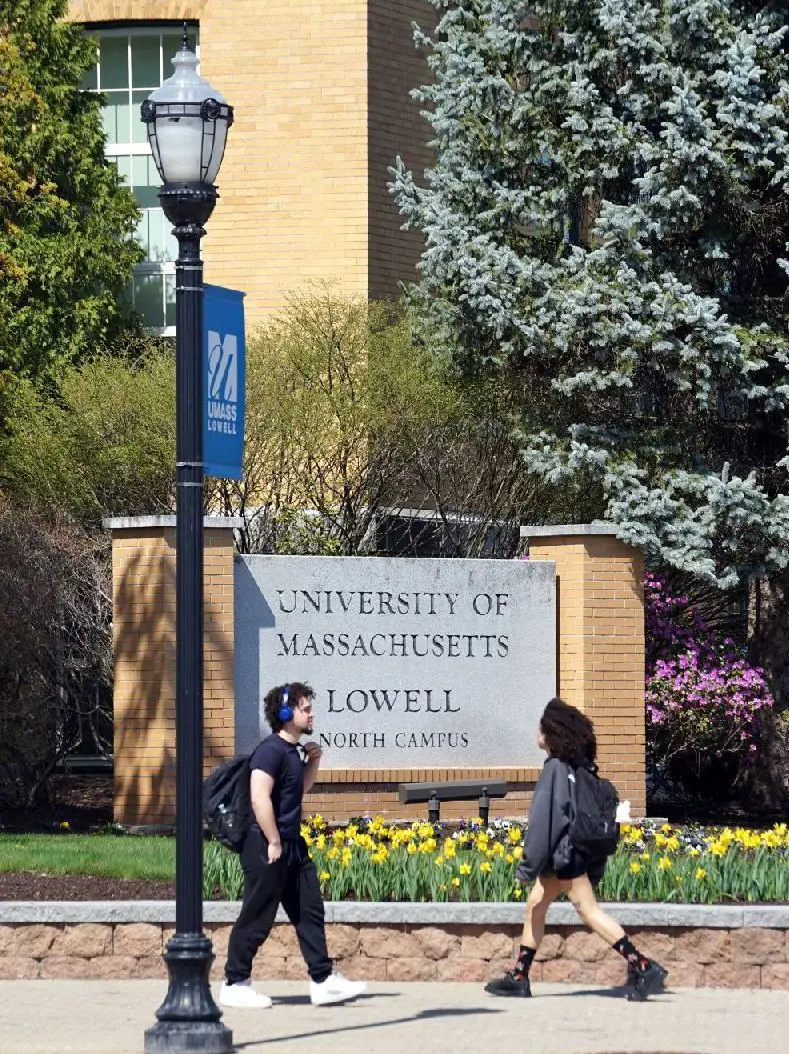 Students walk past UMass Lowell North Campus signe