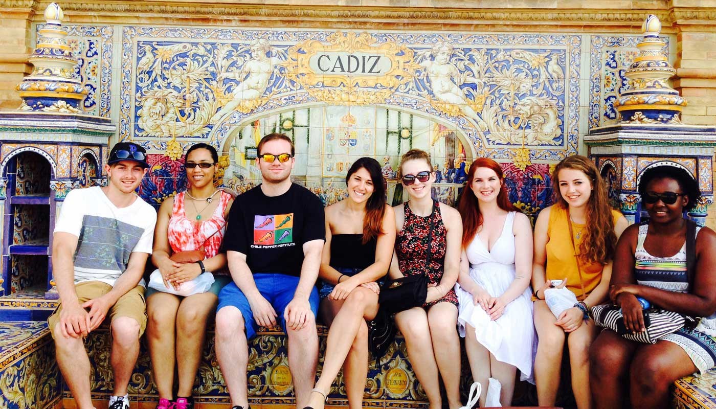 A group of students pose in front of colorful tiles in Cádiz, Spain