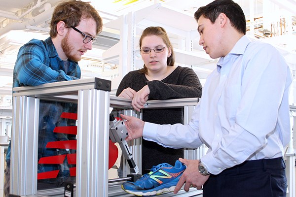 Engineering students Chris White, Samantha Cox and Aaron Choi test the wear on sole materials for running shoes.