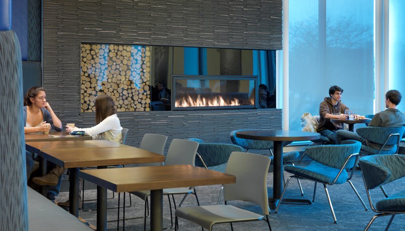 UMass Lowell students sit in front of a fireplace at University Dining Commons in Fox Hall