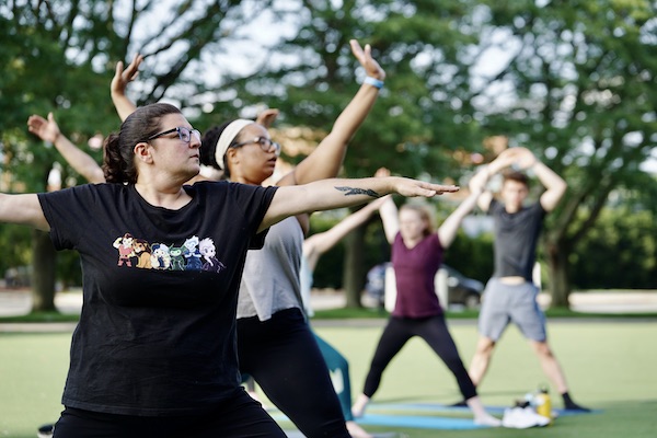 Members of the UML community enjoy a free outdoor yoga class outside the Campus Recreation Center on East Campus last semester.
