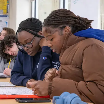 Two students look at a worksheet in a World Languages and Cultures classroom at UMass Lowell.