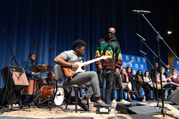 Singer-rapper Wyclef Jean on stage with a UMass Lowell student in Durgin Hall